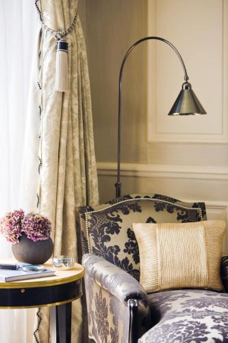a living room with a chair and a lamp at Four Seasons Hotel des Bergues Geneva in Geneva
