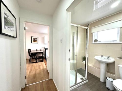 a bathroom with a shower and a sink and a toilet at Fifty Five on Gilmour Street in Eaglesham