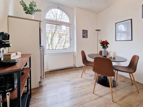Una cocina y un comedor con mesa y sillas. en stayVision LS1 Wohnung 8 - 1 bedroom - 4 guests - top Wi-Fi, en Wuppertal