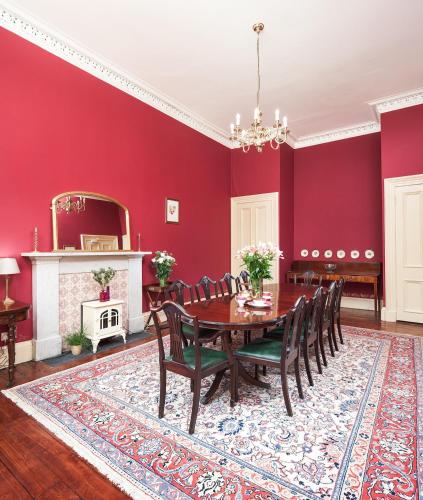 a dining room with red walls and a table and chairs at 7 Crown Gardens Glasgow in Glasgow