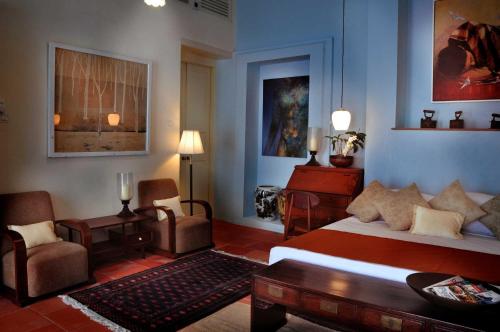 a bedroom with a bed and a table and chairs at 23 Love Lane Hotel in George Town