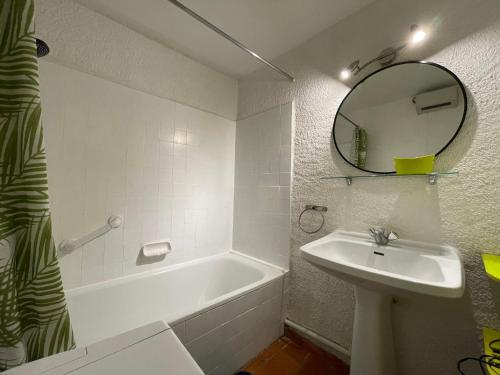 une salle de bain avec une baignoire, un lavabo et un miroir dans l'établissement Vacances conviviales 4-5pers piscine parking, à Fitou