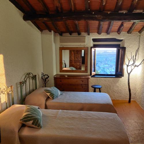 a bedroom with two beds and a mirror and a window at Chez Paul in Massarosa