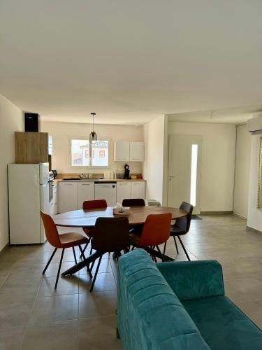 - un salon avec une table et un canapé vert dans l'établissement Maison du Cos, neuve avec 3 chambres et un garage, à Lamothe-Capdeville