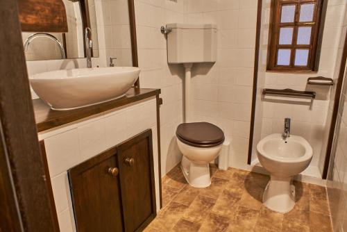 a bathroom with a sink and a toilet and a sink at Chez Paul in Massarosa