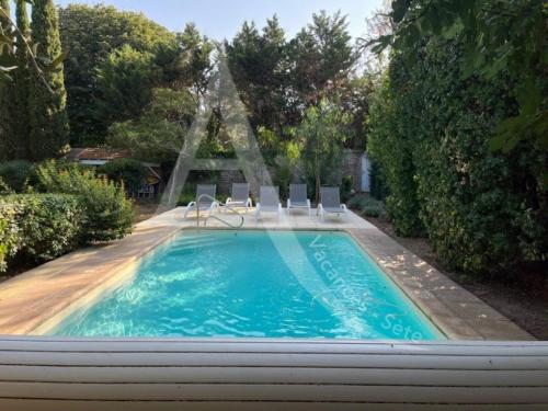 une piscine avec des chaises et une fontaine dans l'établissement Maison de maitre capacite 10 personnes avec piscine, wifi et stationnement, à Sète