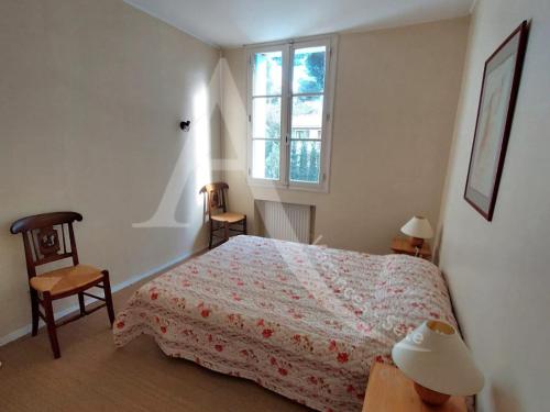 une chambre avec un lit et deux chaises et une fenêtre dans l'établissement Maison de maitre capacite 10 personnes avec piscine, wifi et stationnement, à Sète