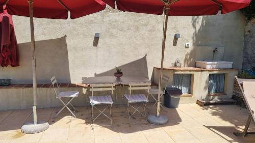 a patio with a table and chairs and an umbrella at IL PICCINO 29, Esperienza Romantica in Borgo.... in Montescudaio