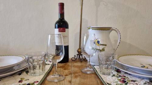 a bottle of wine sitting on a table with glasses at IL PICCINO 29, Esperienza Romantica in Borgo.... in Montescudaio