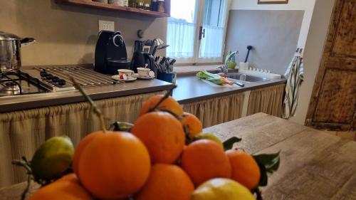 a pile of oranges on a table in a kitchen at IL PICCINO 29, Esperienza Romantica in Borgo.... in Montescudaio