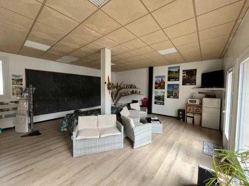 - un salon avec des canapés et un tableau noir sur le mur dans l'établissement Camping 3 étoiles - Piscine - eeiifd, à Marcillac-la-Croisille