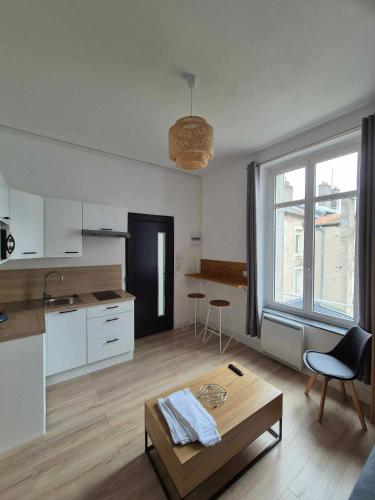 un salon avec une table et une cuisine dans l'établissement Appartement à thermal, à Nancy