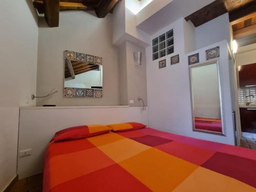 a bedroom with a colorful bed in a room at H2 Via Saffi in Viterbo