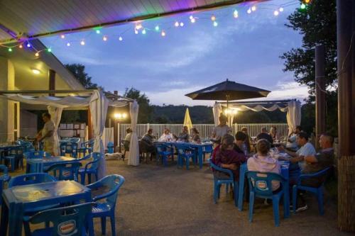 un groupe de personnes assises à des tables dans un restaurant dans l'établissement Camping 4 étoiles - Piscine - eeiige, à Saint-Pardoux
