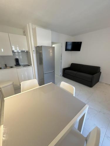 - un salon avec une table blanche et un canapé noir dans l'établissement Résidence Graziella Studio 406, à Juan-les-Pins