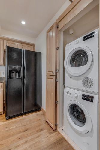 a kitchen with a refrigerator and a washer and dryer at New Listing 2BR 2BA Condo - Mountain Views in Aspen