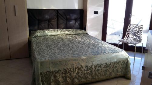 a bedroom with a bed with a headboard and a chair at Monolocale SULE in San Foca