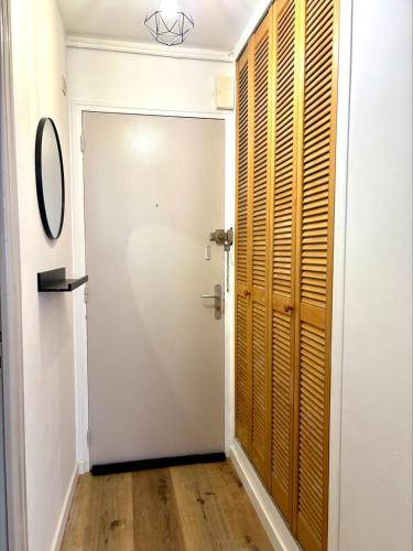 a hallway with a white door and a wooden closet at KLEBER- charmant T2 proche gare in Saint-Brieuc