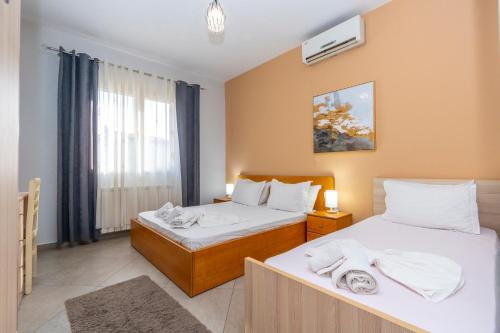 Un dormitorio con dos camas y una ventana. en Hotel Shkodra L, en Shkodër