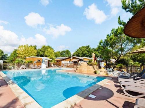 une grande piscine avec des chaises et un toboggan dans l'établissement Camping 4 étoiles - Piscine - eehda0, à Grayan-et-lʼHôpital