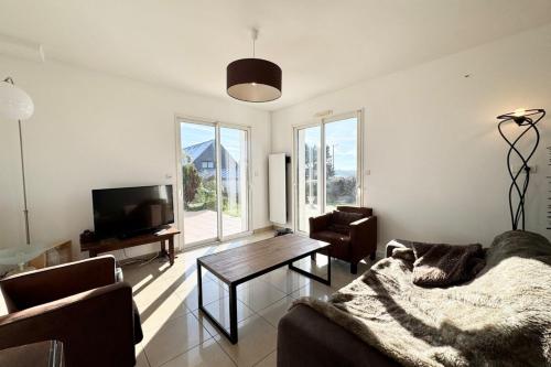 un salon avec un canapé et une télévision dans l'établissement Maison de vacances tout confort - 50m de la Ria, à Plouhinec
