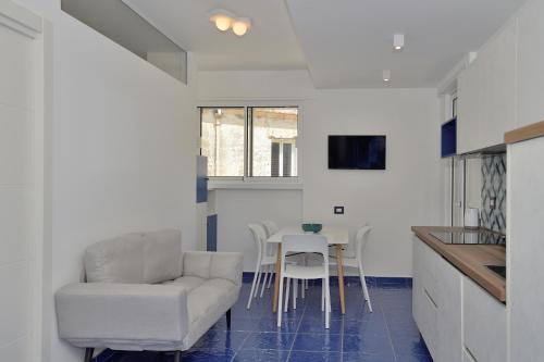 a living room with a chair and a table at L' Orologio del Campanile with terrace in Minori