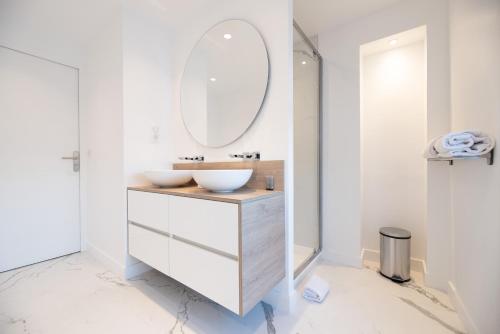 une salle de bain avec un lavabo et un miroir dans l'établissement CIA - flat in Paris Louvre museum with balcony, à Paris