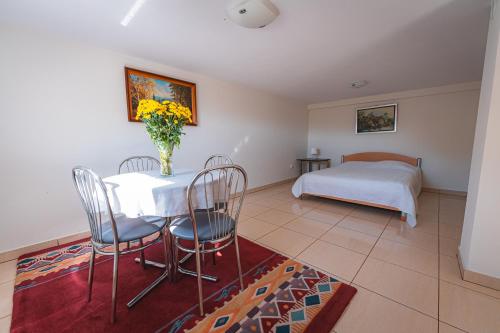 a dining room with a table and chairs and a bed at Bug Na Skarpie - Domek Wypoczynkowy z Jacuzzi i Kominkiem in Drohiczyn nad Bugiem