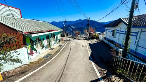 an empty street in a town with mountains in the background at 31 Backpack Guest House in Renai