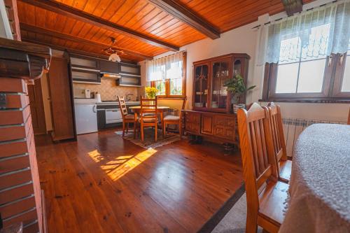 a kitchen and dining room with a table and chairs at Bug Na Skarpie - Domek Wypoczynkowy z Jacuzzi i Kominkiem in Drohiczyn nad Bugiem