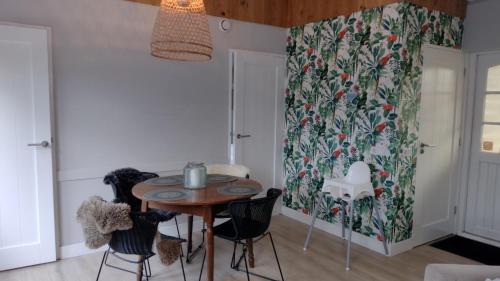 una sala da pranzo con tavolo, sedie e tenda di Rekerlanden 153 a Schoorldam