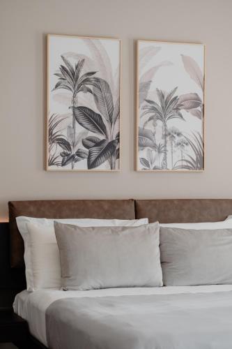 two framed pictures above a bed with white pillows at DimorAmare in Bari
