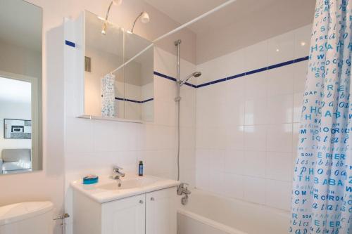 une salle de bain blanche avec un lavabo et une douche dans l'établissement Bel appartement près de la plage, à Saint-Malo