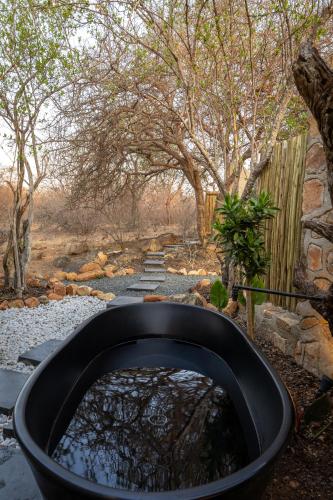 a large black tub filled with water in a yard at Oase by 7 Star Lodges - Greater Kruger Private 530ha Reserve in Hoedspruit
