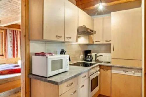 a kitchen with a microwave and a stove top oven at Ferienhaus TRUCKSHÜTTE in Mayrhofen
