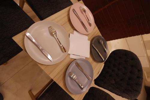 two plates with silverware on a wooden table at Elet Business Hotel in Karachi