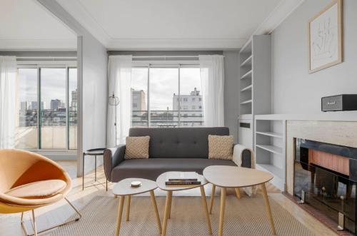 un salon avec un canapé et une cheminée dans l'établissement appartement COSY EN FORET, à Noisy-sur-École