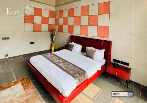 a bedroom with a large bed with a red headboard at Kavyum Retreat in Himatnagar
