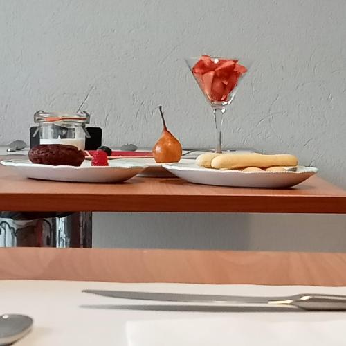 a table with two plates of food and a wine glass at SANTINO'S HOUSE in Peveragno