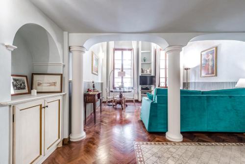a living room with a blue couch in a room at Hostly-Suite Magnifica Al Borgo-Central Elegance in Pisa