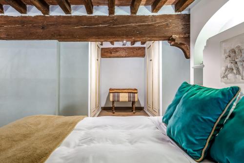 a bedroom with a bed with a green pillow at Hostly-Suite Magnifica Al Borgo-Central Elegance in Pisa