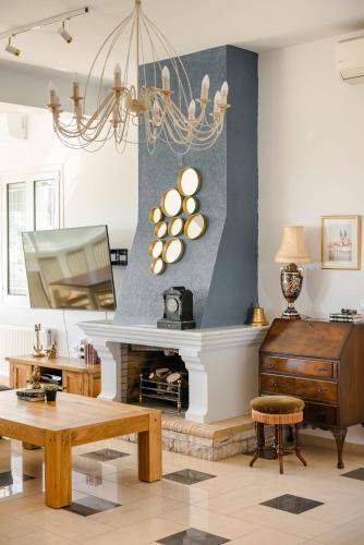 a living room with a fireplace and a chandelier at Pantheon Villa Svoronata in Svoronata