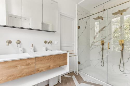 une salle de bain avec un lavabo et une douche dans l'établissement Le Palace Sacré Coeur by ecoflats, à Paris