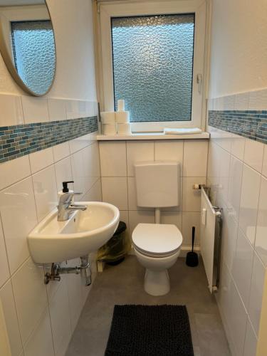a bathroom with a toilet and a sink and a window at Ferienwohnung Rheinglück in Oppenheim