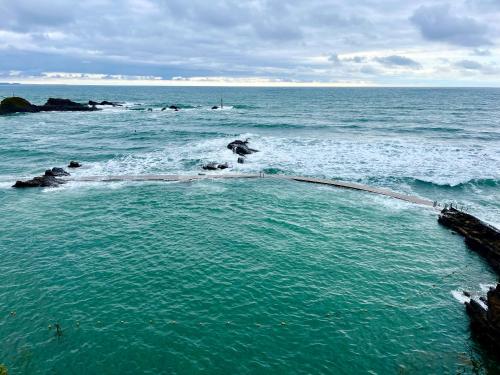 a wave pool in the ocean on a beach at Tamarisk Cabin in Bude