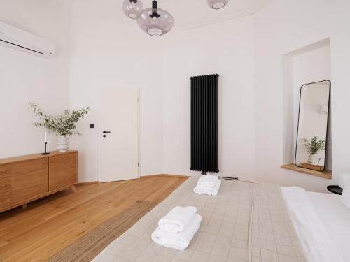 a white room with two towels on a bed at Resort po.spolu in Mokrovraty