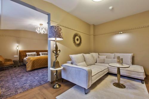 a living room with a couch and a bed at Mestský Hotel Ďumbier in Brezno