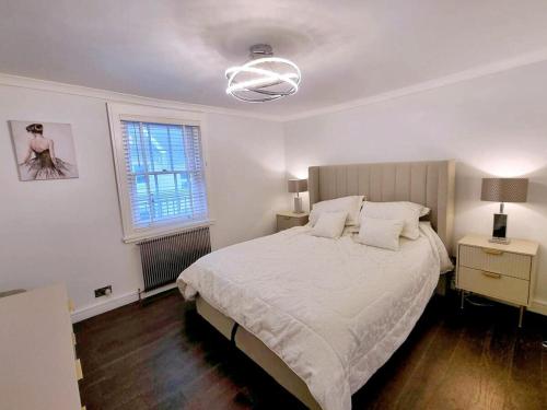 ein Schlafzimmer mit großem Bett und Fenster in der Unterkunft Brighton Cottage By The Sea in Brighton & Hove