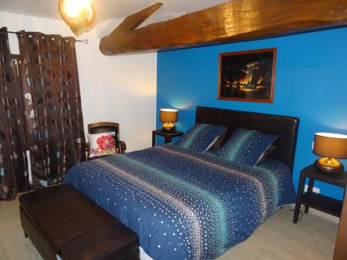 a blue bedroom with a bed with a blue wall at La Fontenelle Chambres d'Hôtes in Sainte-Sévère