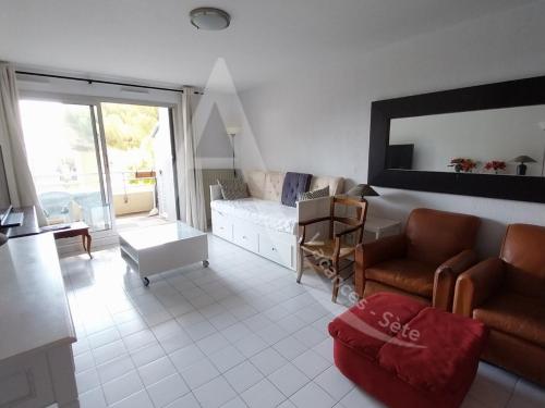 un salon avec un canapé et une table dans l'établissement quartier des plages spacieux appartement 1 chambre avec parking, à Sète